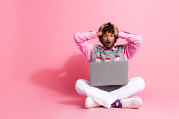 Sticker - Full size photo of nice young man hands touch head laptop empty space wear christmas vest isolated on pink color background