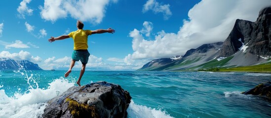 A person standing on a rock by the ocean, arms outstretched, enjoying the beautiful landscape and vibrant nature.