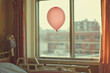 © D.APIWAT - A serene image of a pink balloon floating by a hospital window evokes emotions of care and hope. Gentle light creates a warm atmosphere in room. Ideas for encouraging people with breast cancer