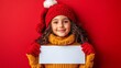 © anantachat - Isolated on Red color background with side space for letters Teenager holding a blank white sign with a cheerful expression for Christmas greetings Stock Photo with copy space
