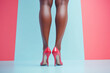© dvoevnore - Long legs in red high heels of african american woman against vibrant color background