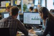 © GoodandEvil - Two colleagues analyzing market data on computers.