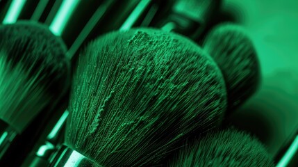 A green background with an array of makeup brushes 