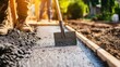 © angel_nt - A construction worker skillfully levels freshly poured concrete in a residential yard, ensuring a smooth surface. The sun shines brightly, enhancing the hardworking ambiance of the scene