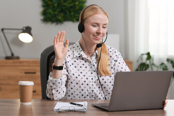 Sticker - Interpreter in headset having video chat via laptop at table indoors