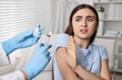 © New Africa - Dental phobia. Dentist with syringe and vial near scared woman in clinic, closeup