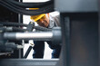 © Parilov - Machinery tractor mechanic checks hydraulic piston hose system equipment on excavator