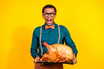 Wall Mural - Photo of furious guy shout loud feel anger hold big turkey for thanksgiving day party isolated yellow color background