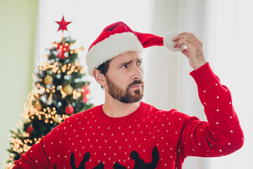 Canvas Print - Photo of nice young man hold look hat pom pom ugly sweater christmas time apartment indoors