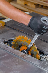 carpenter replaces circular saw in machine tool. Replacing saw in carpentry shop