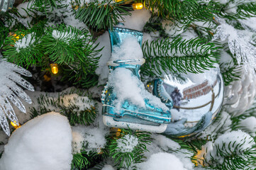 Christmas decorations on a snow-covered Christmas tree. Background of Christmas tree toys. Festive decorations on Christmas Eve. Winter holidays.