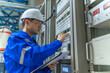 © reewungjunerr - Electrical engineer woman checking voltage at the Power Distribution Cabinet in the control room,preventive maintenance Yearly,Thailand Electrician working at company