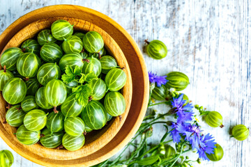 Green Organic Berries Gooseberries.Green gooseberries in a wooden bowl.Gooseberries on the wooden table. Harvest concept. Vegetarian food.