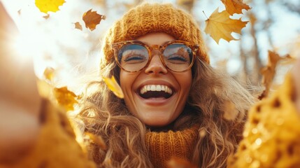 A cheerful woman, wearing stylish glasses and a cozy knit hat, beams with joy as autumn leaves softly descend around her, embodying the spirit of fall happiness.