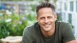© PaulShlykov - Smiling middle aged man wearing a military green T-shirt in cottage garden. Army veteran portrait