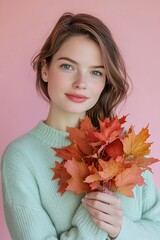 Wall Mural - Model young woman with autumn leaves on pink background