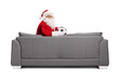 © Ljupco Smokovski - Santa claus sitting on a sofa and holding a football