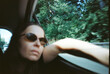 © Synchro Shoot/Stocksy - Woman enjoying a road trip in sunglasses on a sunny day (analog image)
