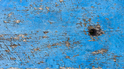 Old weathered wooden plank with blue cracked paint. Abstract background.
