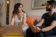 © tessy morelli/Stocksy - Couple at home with laptop in conversation