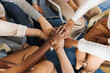 © Daniel Zapata/Stocksy - Group of unrecognizable people joining hands.