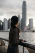 © Heng Yu/Stocksy - Woman Looking at Hong Kong City Skyline by Waterfront