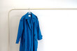 © Bisual Studio/Stocksy - Blue Coat On Hanger With Minimalist Clothing Rack