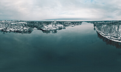 The Dvina River flowing in the city of Polotsk in the winter season. Belarus. trees are wrapped under a blanket of food