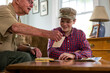 © Raymond Forbes LLC/Stocksy - Senior Veteran family Great Grandfather  Looking at photos