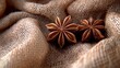 © Jack - Anise Stars and Seeds: A detailed shot of star anise and its seeds scattered on a soft fabric, showcasing their intricate shapes and rich brown color, with a warm light accentuating their texture.