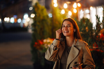 Happy woman listening music walking night city street