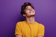 © Muneer - Happy joyful smiling young man looking aside up thinking new opportunities, dreaming and feeling inspired, isolated on a purple background.