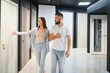 © Serhii - Portrait of smiling young man and woman shopping in the hardware store choosing different door options