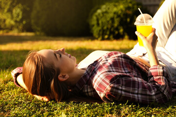 Wall Mural - Woman resting on green lawn in park