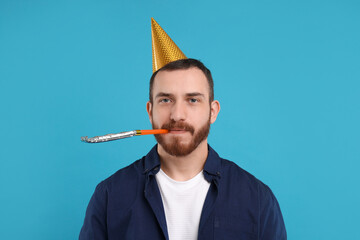 Poster - Man in party hat with blower on light blue background