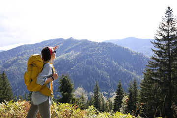 Poster - Young hiker with backpack in mountains on sunny day