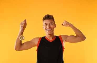 Wall Mural - Happy winner with golden medal on yellow background