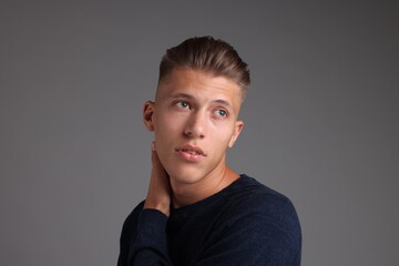 Wall Mural - Handsome young man with stylish haircut on grey background