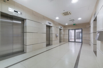 spacious lobby in an office building. modern elevators with metal doors. the room is .decorated with