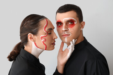 Sticker - Young couple with painted faces on light background, closeup