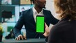 © DC Studio - Store manager holding smartphone with greenscreen layout at cash register, working on commercial activity with clients. Woman retail clerk using chromakey display and isolated mockup. Camera A.