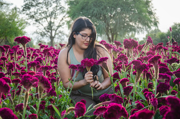 latina girl with long hair posing on purple flowers