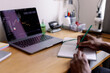 © Oleksii Syrotkin/Stocksy - Cropped man watching market graph on laptop and writing in notebook