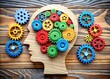 © hapsuwanArt - Colorful wooden gears interact with a human brain, symbolizing unique thinking patterns, individuality, and creative problem-solving associated with autism and neurodiverse minds.