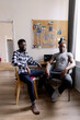 © Oleksii Syrotkin/Stocksy - Black men looking at camera during sitting in chair at desk at home