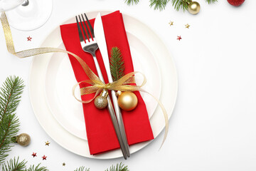 Poster - Christmas table setting with plate, cutlery, napkin, glasses and festive decor on white background, flat lay