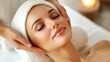 © Maria Mikhaylichenko - Serene woman enjoying luxurious facial treatment at spa, eyes closed in blissful relaxation. Soft lighting enhances the peaceful ambiance of self-care.