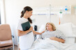 © Santi Nuñez/Stocksy - Nurse comforting patient in hospital bed