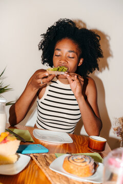Black woman eating avocado toast for breakfast