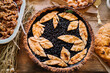 © Adrian Cotiga/Stocksy - Blueberry pie with decorative leaf crust on a table.
